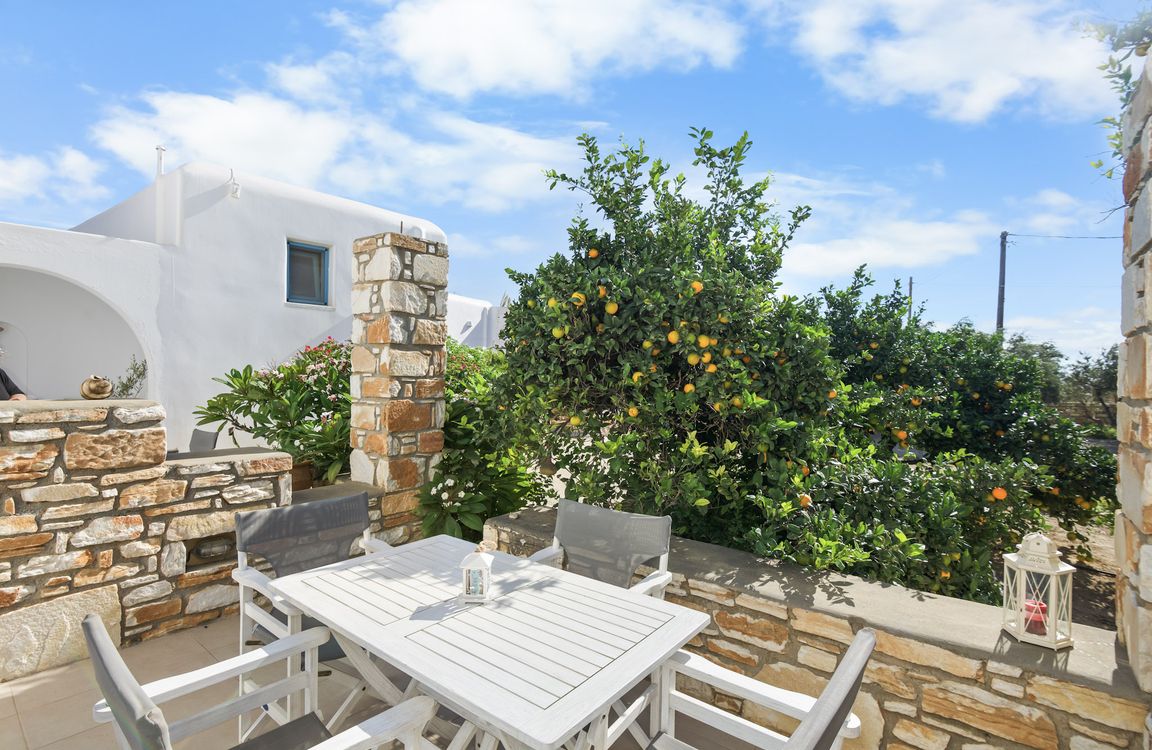 Margarita apartment at Flora Apartments, Drios, Paros – stone-walled terrace among orange trees