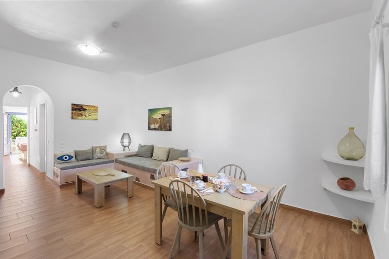 Margarita apartment, Flora Apartments Paros – living room with built-in sofa and dining area