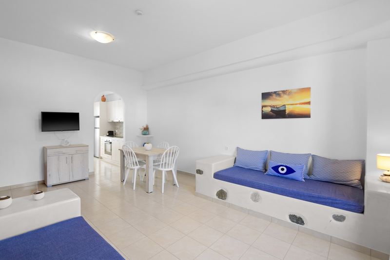 Rose apartment, Flora Apartments Paros – living room with built-in sofas and dining area