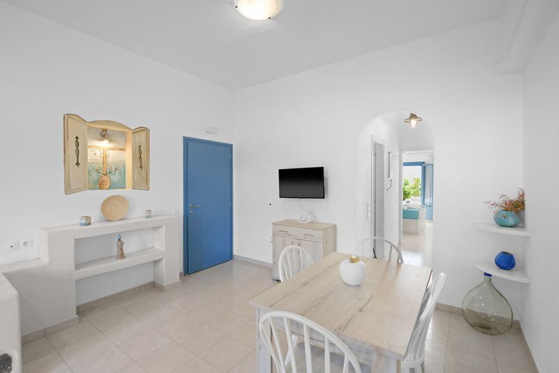 Rose apartment, Flora Apartments Paros – living room with built-in sofas and dining area